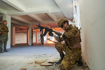 Image showing Soldier in action near window changing magazine and take cover