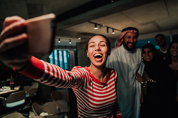 Image showing Diverse team of businessmen taking selfie photos on smartphone while in modern office