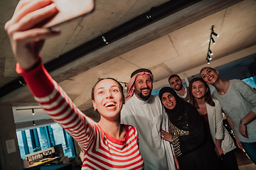 Image showing Diverse team of businessmen taking selfie photos on smartphone while in modern office