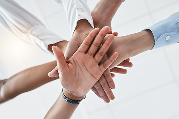 Image showing Hands, collaboration and motivation with a team in business standing in a huddle or circle from below. Teamwork, success and unity with an employee group working together with a goal or vision