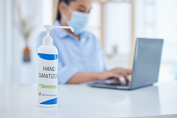 Image showing Hand sanitizer, covid and business woman typing on a laptop at desk in her office with face mask. Hygiene, technology and professional employee working on project with computer during corona pandemic