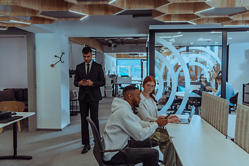 Image showing Young group of business people brainstorming together in a startup space, discussing business projects, investments, and solving challenges.