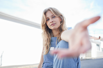 Image showing Portrait of girl in the city with hand reaching forward, sitting in the street. Student, education and young woman in college with hands out in urban road. Motivation, encourage and freedom in youth