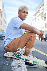 Image showing Skateboard, street style and city with a black man on the sidewalk in the day for skating, sport or leisure. Skater, recreation and urban with a cool or edgy male sitting on a pavement with his board