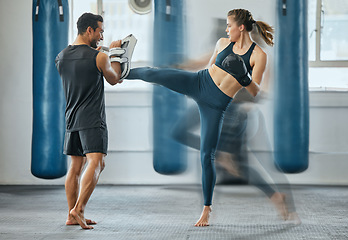 Image showing Fighting female training with coach, learning kickboxing exercise at gym and doing cardio fitness workout for wellness with trainer at health club. Woman and man staying, active, healthy and sporty