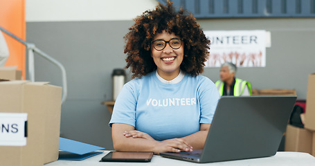 Image showing Volunteer woman, laptop and portrait at clothes drive with smile, community service and kindness at desk. Girl, computer and social responsibility with donation boxes, charity and happy for helping