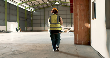 Image showing Warehouse, back of woman and engineer walking at empty industrial plant, manufacturing production or construction. Factory, rear view and worker or technician check storage, distribution or logistics