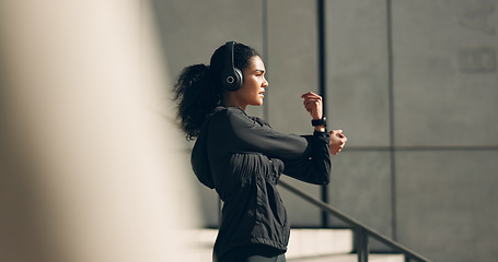 Image showing Runner woman, headphones and warm up on stairs for music, vision and ideas in city, workout and training. Girl, thinking and listen on steps with streaming subscription, wellness and stretching arms