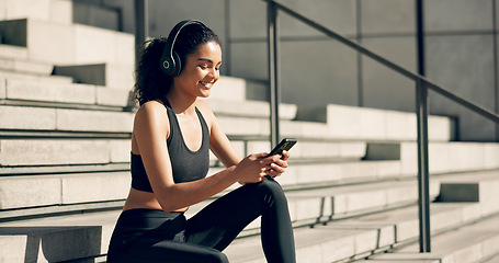 Image showing Runner woman, headphones and phone on stairs with music, smile and relax in city, workout and training. Girl, smartphone and happy with audio streaming subscription with typing, social media or app