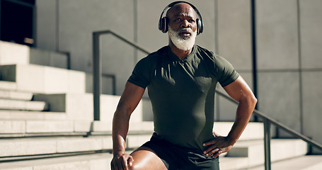 Image showing Fitness, headphones and black man on stairs in city, sweat after workout and exercise for body health. Music, senior athlete and steps in urban town, listening to audio and serious, thinking or tired