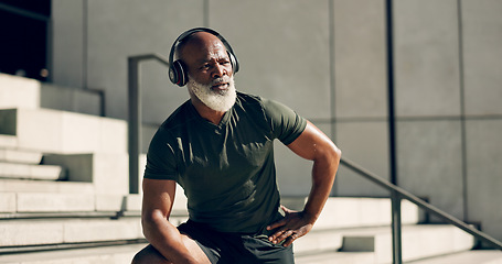 Image showing Fitness, headphones and black man on steps in city, sweat after workout and exercise for body health. Music, senior athlete and stairs in urban town, listening to audio and serious, thinking or relax