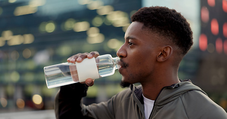 Image showing Black man, drinking water and fitness in city after workout, exercise or outdoor training for natural sustainability. Thirsty African male person with mineral drink on break for hydration in town