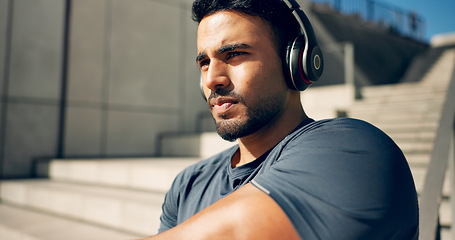 Image showing Fitness, music headphones and man on stairs in city, workout and exercise for body health. Radio, serious athlete and person on steps in urban town, listening to audio or podcast, sound and thinking