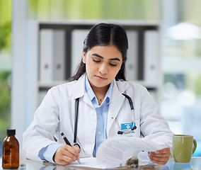 Image showing Doctor, healthcare worker and gp reading, writing and planning test results, patient record and medical research in a hospital or medical clinic. Organized healthcare expert working on treatment plan