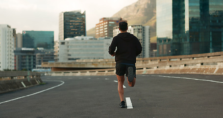 Image showing Man, back and running in morning on city, street and bridge for fitness, workout and marathon training. Athlete, person or exercise on South Africa road for wellness, health or triathlon performance