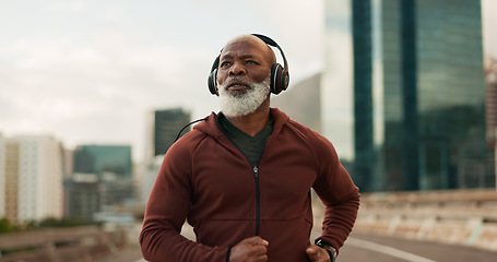 Image showing Mature, athlete and running in city with headphones for fitness, workout or marathon training music. Black man, thinking or exercise podcast in South Africa for cardio wellness, health or sport radio