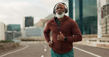 Image showing Mature, person and running in city with headphones for fitness, workout and marathon training music. Black man, athlete or exercise podcast in South Africa for cardio wellness, health or sports radio