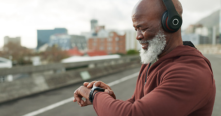 Image showing Man, smart watch and headphones in city for workout, exercise results and fitness performance. Happy senior african runner check timer, clock and healthy training progress with music in urban street