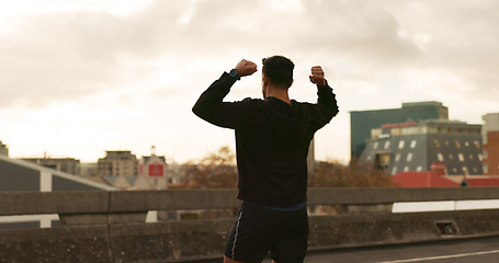 Image showing Man, runner or victory in city for exercise time, fitness progress or training goal. Male person, athlete or cheers or workout performance on cloudy morning in street, challenge or health celebration