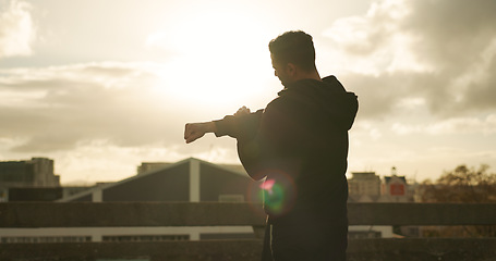 Image showing Man, stretching and fitness in city for workout, exercise or outdoor training with cloudy sky. Rear view, male person or athlete in flare, body warm up or arm stretch getting ready in an urban town