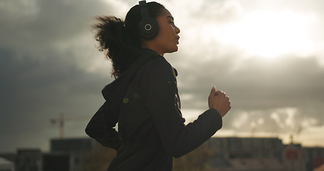 Image showing Exercise, music and a sports woman running in the city for health or cardio preparation of a marathon. Fitness, wellness or training and a young runner or athlete listening to audio with headphones