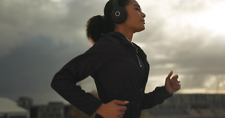 Image showing Fitness, music and a woman running in the city for health or cardio preparation of a marathon. Exercise, wellness or sports training and a young runner or athlete listening to audio with headphones