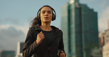 Image showing Fitness, music and a sports woman running in the city for health or cardio preparation of a marathon. Exercise, wellness or training and a young runner or athlete listening to audio with headphones