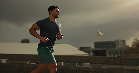 Image showing Running, city or man with workout in training, cardio jog or fitness for marathon competition. athlete, wellness or strong body for france with progress, road or health lifestyle and overcast sky