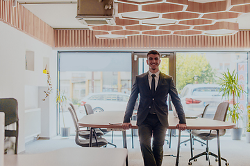 Image showing A businessman sitting on his desk, taking a moment to rest and unwind from a demanding workday, displaying a sense of tranquility and relaxation amidst the corporate environment