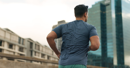 Image showing Back, running and a sports man in the city for cardio training to improve fitness for a marathon. Exercise, workout or health with a young runner or athlete in an urban town for a speed challenge