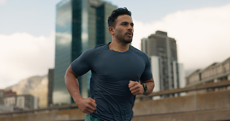 Image showing Exercise, running and a sports man in the city for cardio training to improve fitness for a marathon. Wellness, workout or health with a young runner or athlete in an urban town for a speed challenge