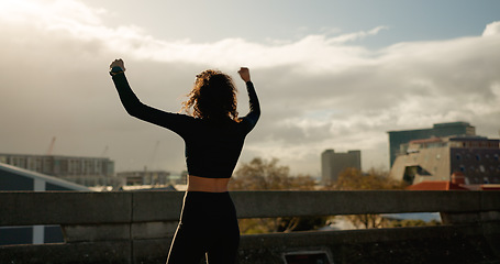 Image showing Woman, freedom and winning in city for fitness achievement, workout or outdoor training success. Rear view of female person, runner or athlete in celebration for goals or victory in an urban town