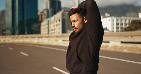 Image showing Man, stretching and fitness in city for exercise, workout or outdoor training on road or street. Active male person, runner or athlete in body warm up or arm stretch getting ready in an urban town