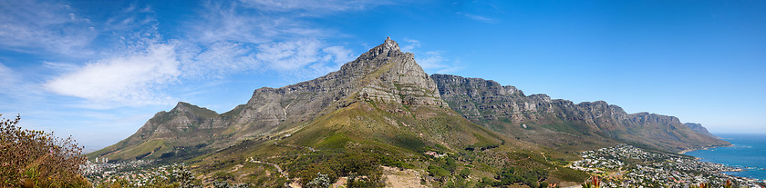 Image showing Beautiful Table Mountain with lush greenery and nearby urban city in a wide angle landscape in summer. Scenic view of the nature in South Africas popular National landmark natural tourist destination