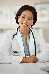 Image showing Black woman doctor at her desk, happy and sitting at her office in a clinic or hospital. Success, work and a smile, young female healthcare professional or career medical worker, a leader in medicine