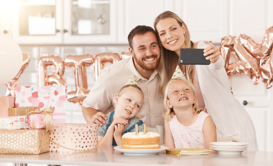 Image showing Family birthday party in kitchen, mom photograph on phone camera for social media and mother and father celebrate. Gifts, cake, food and foil balloons at home with dad and twin sisters.