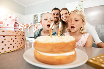 Image showing Birthday, cake and celebration with a girl and her sister blowing out candles and making a wish with her family in the background. Celebrating, party and growing up with children and their parents