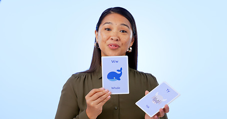 Image showing Asian woman, teacher and flash cards for teaching, education and isolated on studio background. Portrait, learning and show for development, elearning and study for english, animals and presentation
