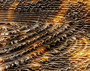 Image showing Water ripple pattern on golden liquid for creative copy space background. Abstract closeup of wave pattern on a puddle or lake with splash effect. Yellow and brown circle reflection on honey or oil