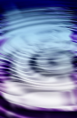 Image showing CGI abstract ripple effect of liquid with purple reflection of wavy pattern and texture. Hypnotizing wallpaper background of fluid color spectrum. Psychedelic and cosmic art or esoteric surface.