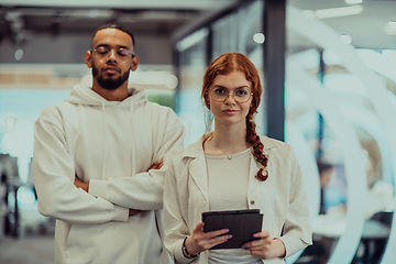 Image showing In a modern office African American young businessman and his businesswoman colleague, with her striking orange hair, engage in collaborative problem-solving sessions