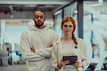 Image showing In a modern office African American young businessman and his businesswoman colleague, with her striking orange hair, engage in collaborative problem-solving sessions