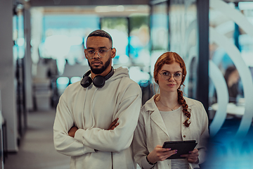 Image showing In a modern office African American young businessman and his businesswoman colleague, with her striking orange hair, engage in collaborative problem-solving sessions