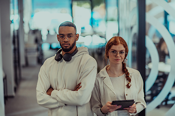 Image showing In a modern office African American young businessman and his businesswoman colleague, with her striking orange hair, engage in collaborative problem-solving sessions