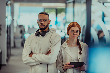 Image showing In a modern office African American young businessman and his businesswoman colleague, with her striking orange hair, engage in collaborative problem-solving sessions