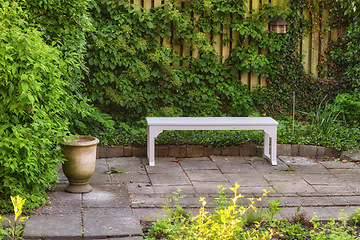 Image showing Gardeners corner. Private chair in green garden in the beautiful outdoors. A place with green nature views outside. Resting area for relaxation and isolated seating area surrounded by natural life.