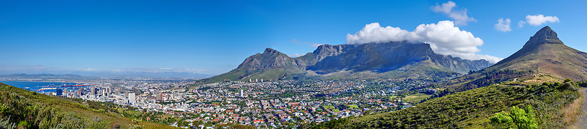 Image showing Panoramic scene of Cape Town, South Africa. Table Mountain, Lions Head and Signal Hill against a blue sky background, overlooking the city. Aerial view of the urban and natural environments