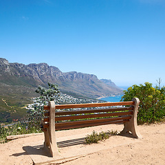 Image showing Bench with a beautiful view of the mountain and sea against a clear blue sky background with copy space. Landscape of relaxing outdoor seating on cliff to enjoy zen moment in Cape Town, South Africa