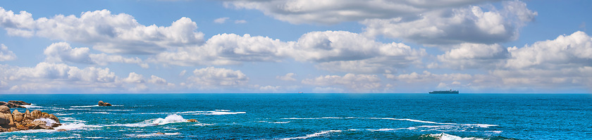 Image showing Landscape banner of a scenic ocean view in Camps Bay, Cape Town in South Africa. Panoramic scenery of the beach and waves rolling in from the sea against a blue cloudy sky in summer