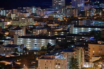 Image showing Cape Town at night. Aerial view of urban construction in the evening. The landscape of an electrically lit up town at nighttime. Night cityscape of the beautiful city of Cape Town in South Africa.